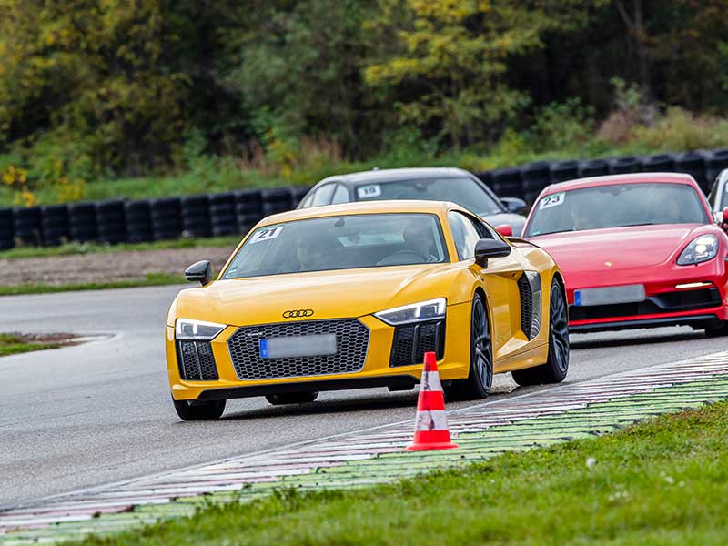 Audi R8 auf der Rennstrecke mit rotem Porsche
